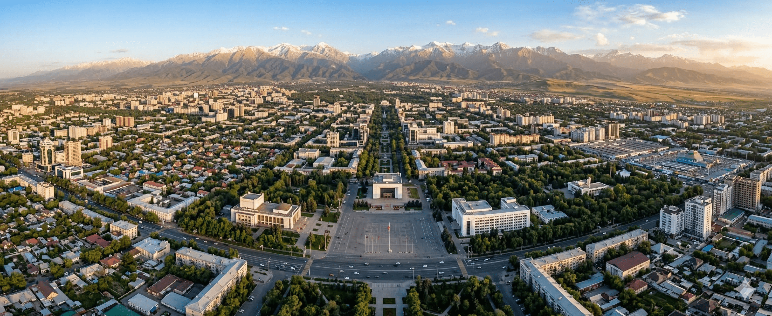 Scenic aerial view of Bishkek city with mountain ranges in the distance.