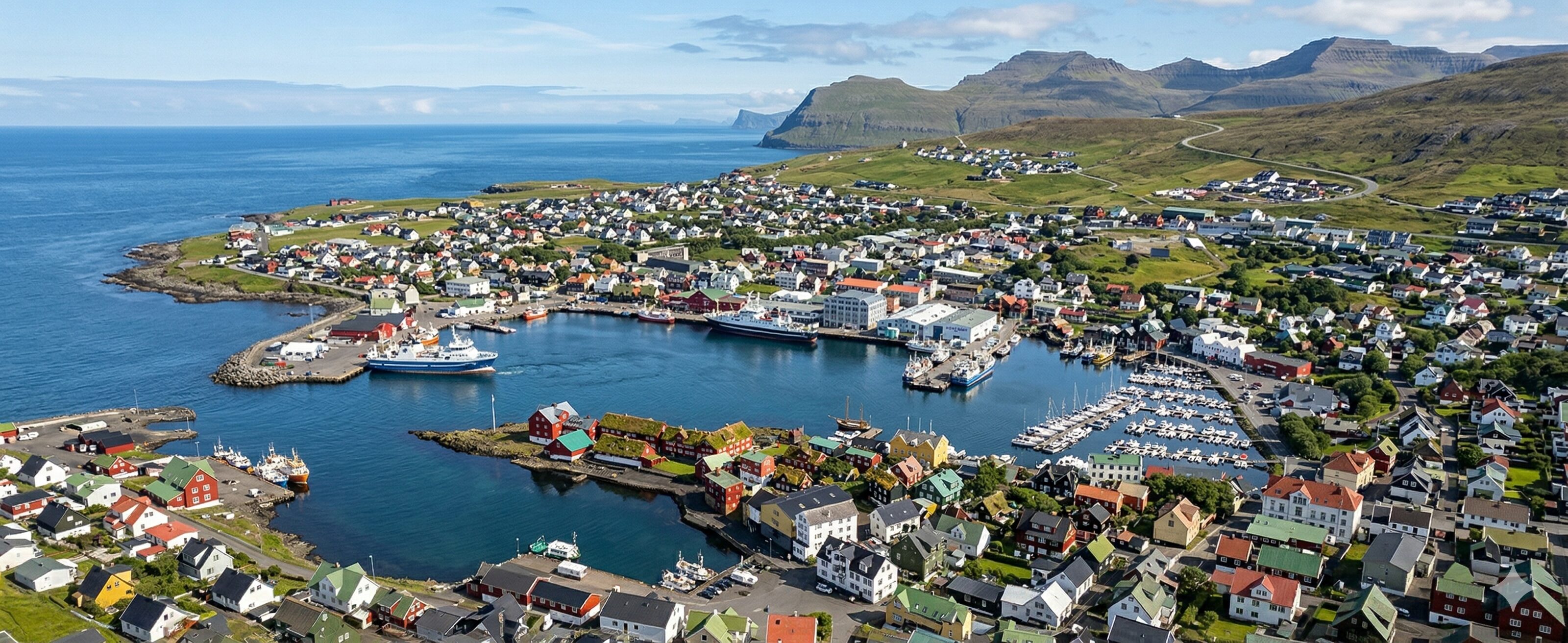 Realistic aerial panoramic photograph of Tórshavn, the capital of the Faroe Islands, nestled around its natural harbor.