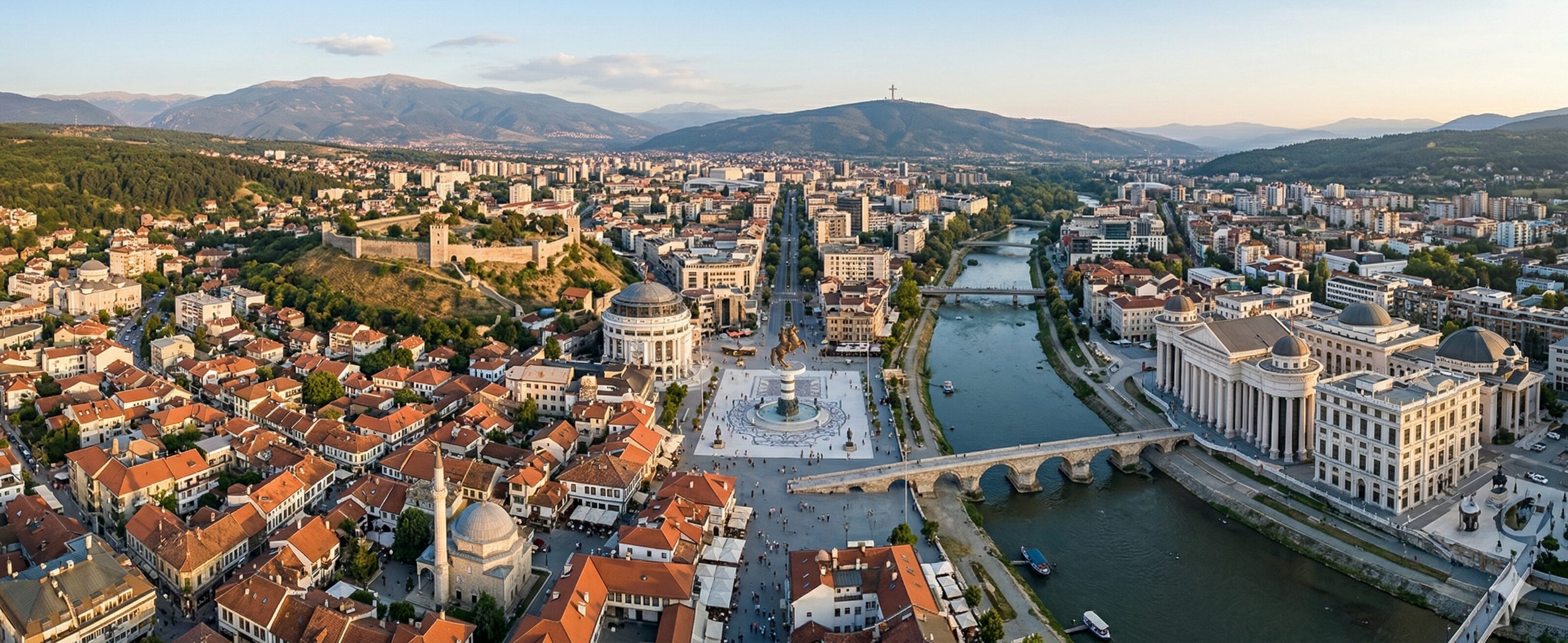 High-altitude, realistic panoramic aerial photograph capturing the expansive city of Skopje, North Macedonia.